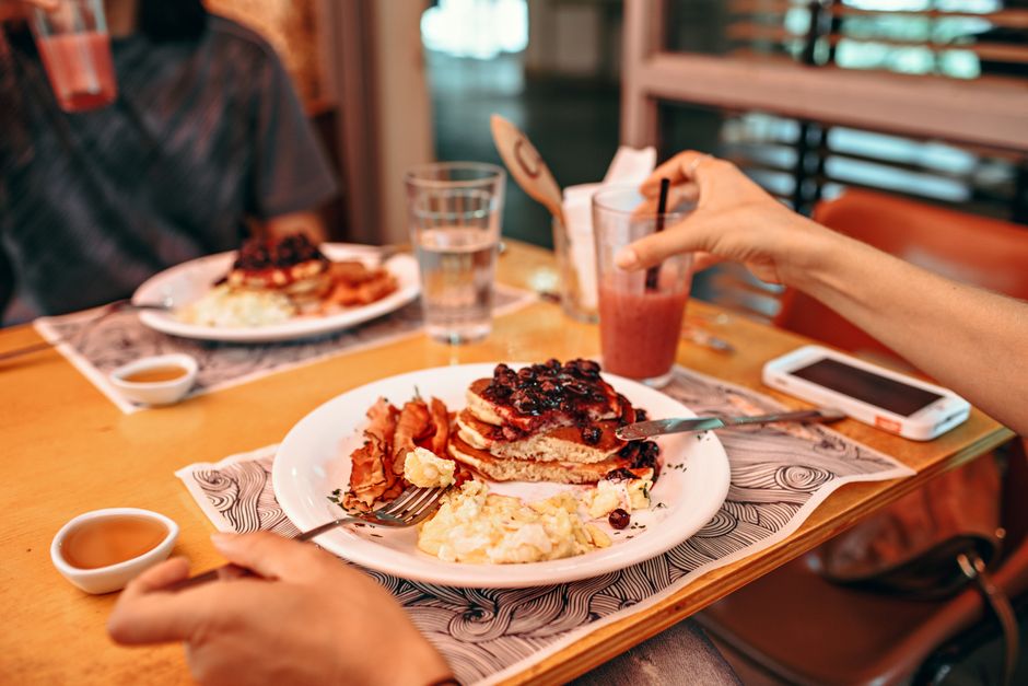 Brunchtafel met pannenkoeken, eieren en koffie in een Amsterdams café